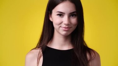 4k video of one girl smiles and shows his tongue over yellow background. Concept of emotions.