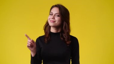 Bir kadının durduğu ve sarı arka planda yasaklandığı 4k yavaş çekim videosu. Duyguların kavramı.