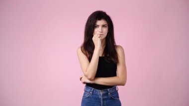 4k video of one woman planning something and points upwards on pink background. Concept of emotions.