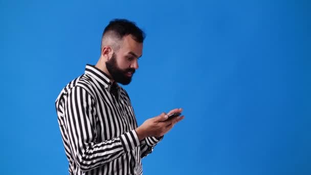 Video One Man Scrolling Messenger Smiling Blue Background Concept Emotions — Stockvideo