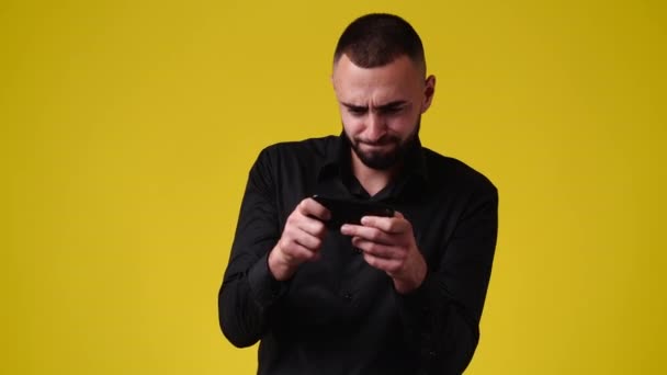 Видео Один Человек Играет Игры Своем Телефоне Жёлтом Фоне Концепция — стоковое видео