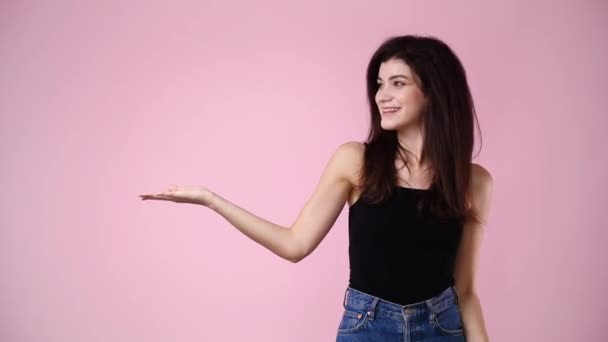 4K视频显示一个女孩在左边 大拇指向上伸出粉红的背景 情绪的概念 — 图库视频影像