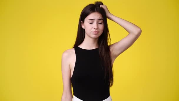 Video One Girl Touches Her Hair Wonders Yellow Background Concept — Vídeo de Stock