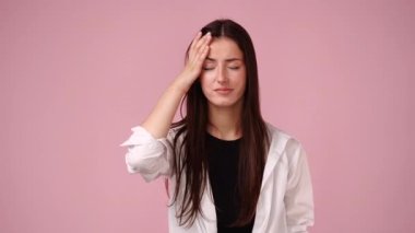 4k slow motion video of one girl having headache over pink background. Concept of emotions.