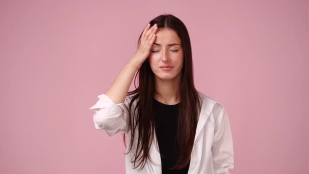 4K慢动作视频一个女孩有头痛粉红背景 情绪的概念 — 图库视频影像