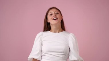 Pembe arka planda çapraz elleri olan bir kızın 4K videosu. Olumsuz duygu kavramı.