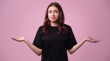4k video of one girl with negative facial expression over pink background. Concept of emotions.