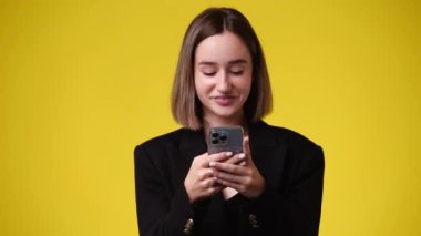 4k video of one girl sending messages on yellow background. Concept of emotions.