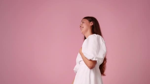 Video Van Een Meisje Wijst Naar Links Roze Achtergrond Concept — Stockvideo