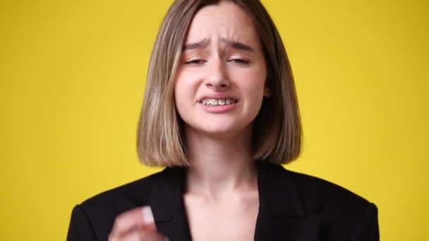 一个女孩在黄色背景下面部表情消极的4K视频 情绪的概念 — 图库视频影像