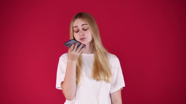 Video Von Einem Mädchen Das Ihr Handy Über Rotem Hintergrund — Stockvideo