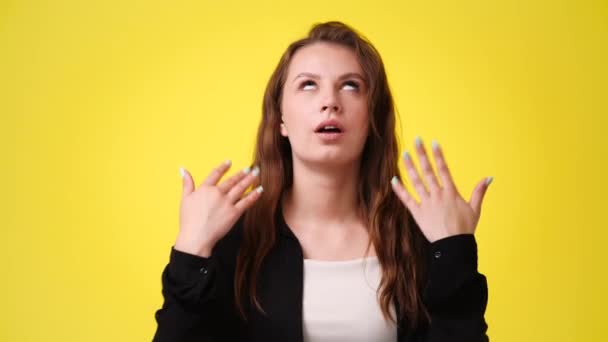 黄色の背景の上にビデオをポーズする1人の女の子の4Kビデオ 感情の概念 — ストック動画