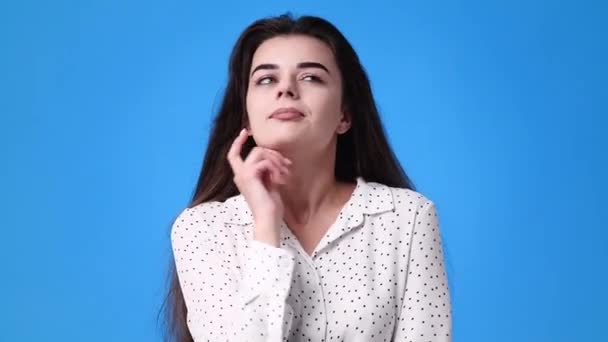 青い背景の上にビデオをポーズしている1人の女の子の4Kビデオ 感情の概念 — ストック動画