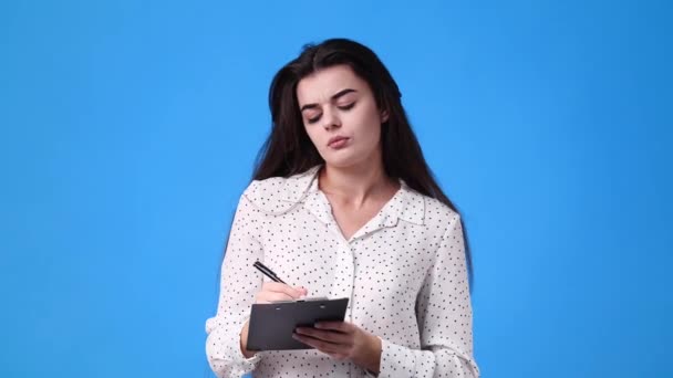 Video Van Een Meisje Die Notities Maakt Een Blauwe Achtergrond — Stockvideo
