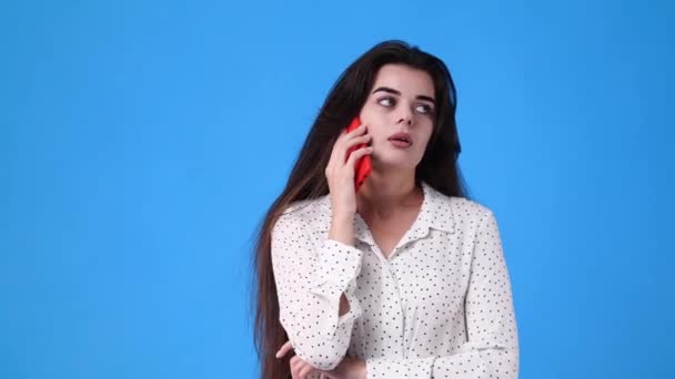 Video Dari Seorang Gadis Berbicara Melalui Telepon Latar Belakang Biru — Stok Video