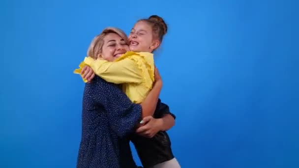 Video One Woman Hugs Little Girl Both Smile Blue Background — Stock video