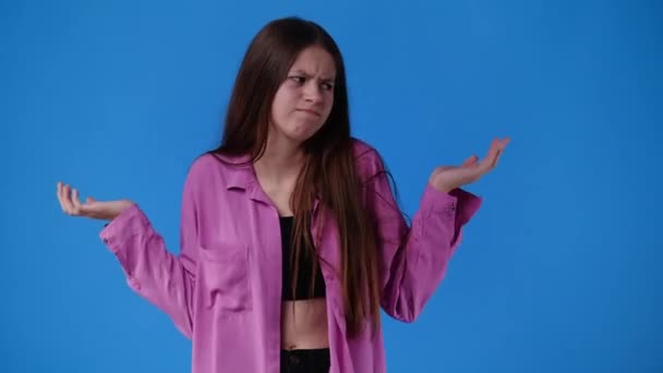 Video One Girl Crosses His Arms Thinking Something Blue Background — Vídeos de Stock
