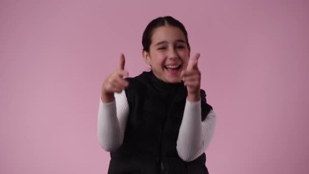 4K视频 一个年轻女孩指着一个粉红背景的人 情绪的概念 — 图库视频影像