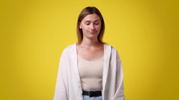 腕を交差し 黄色の背景の上に何かに否定的に応答する1人の女性の4Kビデオ 感情の概念 — ストック動画