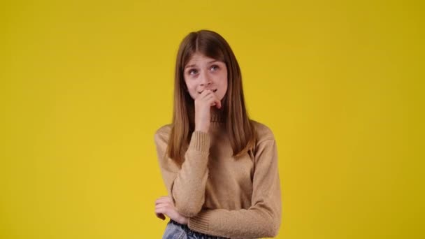 Video Una Chica Duda Sobre Fondo Amarillo Concepto Emociones — Vídeo de stock
