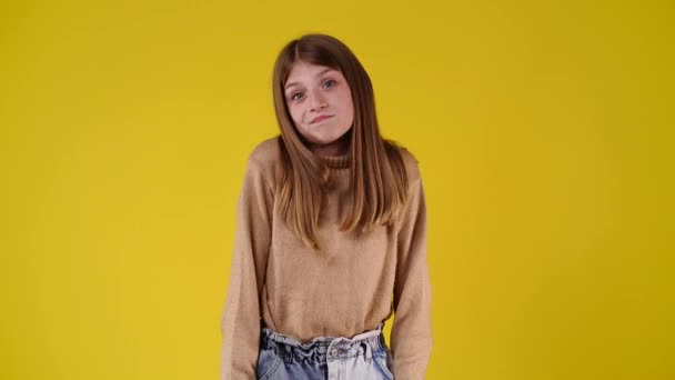 Zeitlupenvideo Von Einem Mädchen Zweifelt Und Weiß Nicht Auf Gelbem — Stockvideo
