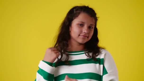 黄色い背景の上に髪に触れた1人の少女の4Kビデオ 感情の概念 — ストック動画