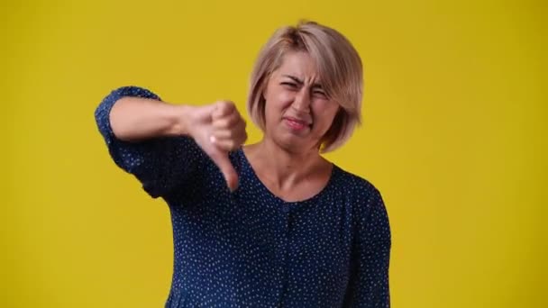 Video One Woman Negative Facial Expression Showing Thumb Yellow Background — Wideo stockowe
