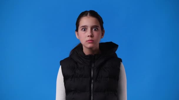 Video Una Joven Sorprendida Pone Mano Cara Sobre Fondo Azul — Vídeos de Stock