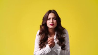 Sarı arka planda duygusal olarak sevinen bir kızın 4K videosu. Duyguların kavramı.