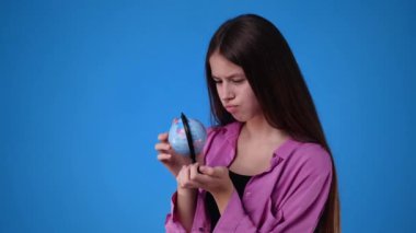 4k video of one girl looking at small globe. Concept of emotions.