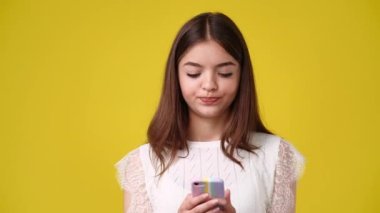 4k video of one girl sending messages on yellow background. Concept of emotions.