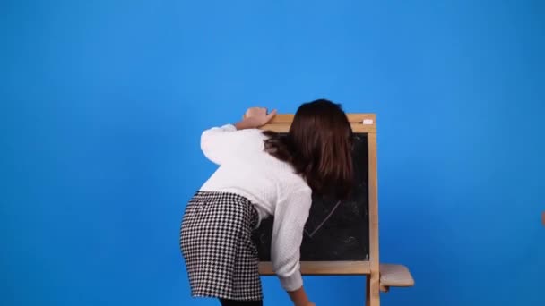 Video Jedné Dívky Pózující Pro Video Tabulí Nad Modrým Pozadím — Stock video