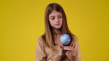 4k video of one girl looking at small globe. Concept of emotions.