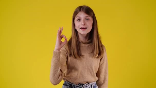Video Von Niedlichen Mädchen Das Zeichen Auf Gelbem Hintergrund Zeigt — Stockvideo