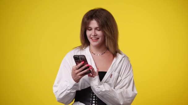 Video Girl Using Her Phone Yellow Background Concept Emotion — Vídeos de Stock