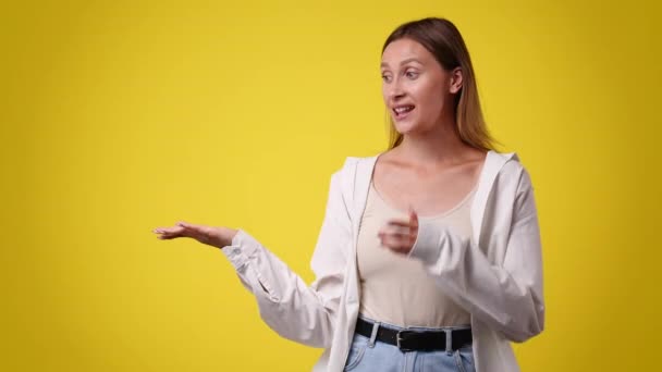 Video One Girl Pointing Left Yellow Background Concept Emotions — Stockvideo