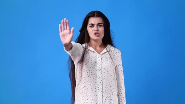 青い背景の上に停止標識を示す1人の少女の4Kビデオ 感情の概念 — ストック動画