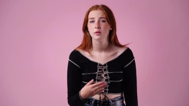 ピンクの背景に狡猾な顔の表情を持つ女の子の4Kビデオ アイデアを持つ少女の概念 — ストック動画