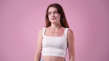 Mavi arka planda negatif yüz ifadesi olan bir kızın 4K videosu. Duyguların kavramı.