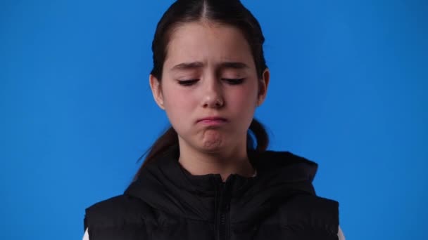 Mavi Arka Planda Negatif Yüz Ifadesi Olan Bir Kızın Videosu — Stok video