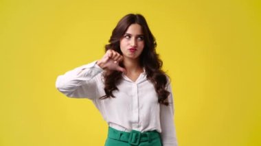 Sarı arka planda başparmağını gösteren 4K video. Olumsuz duygu kavramı.