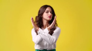 Sarı arka planda bir kızın hayır işaretini 4K videosu. Duyguların kavramı.
