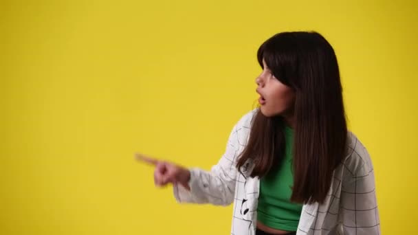 Video One Girl Pointing Left Yellow Background Concept Emotions — Video Stock