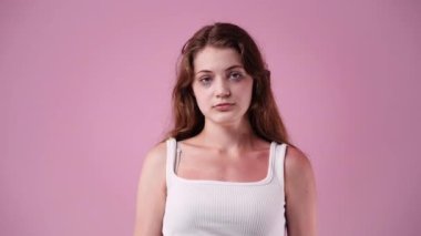 4k video of girls facial expression on pink background. Concept of emotions.