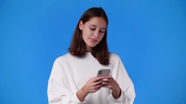 青い背景にメッセージを送る1人の少女の4Kビデオ 感情の概念 — ストック動画