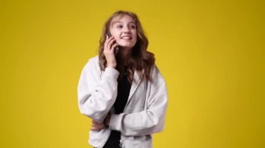 4k video of cute girl smiling over yellow background. Concept of emotions.