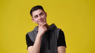 4k video of a man thinking about something over yellow background. Concept of emotions.
