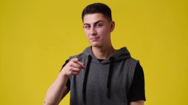 4k video of man making telephone gesture near head call me sign on yellow background. Concept of calling symbol offering communication.