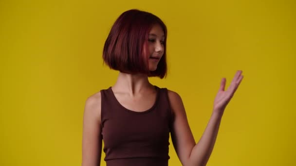 Video One Girl Pointing Right Yellow Background Concept Emotions — Vídeos de Stock