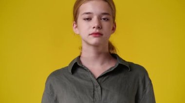 4k video of cute girl smiling over yellow background. Concept of emotions.